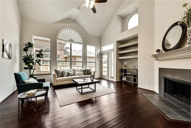 a living room with furniture a fireplace and a floor to ceiling window