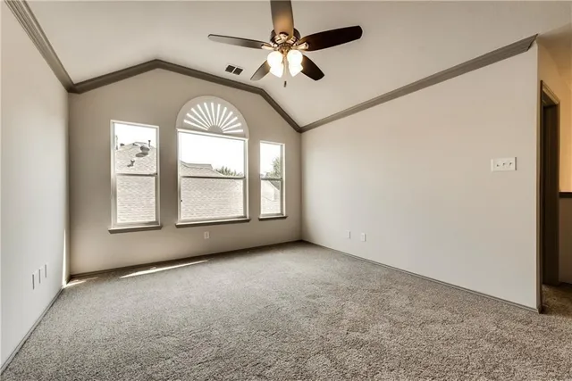 an empty room with windows and ceiling fan