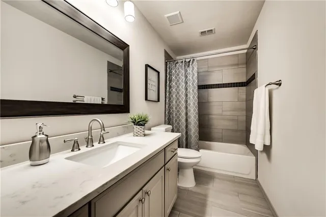 a bathroom with a double vanity sink toilet mirror and shower