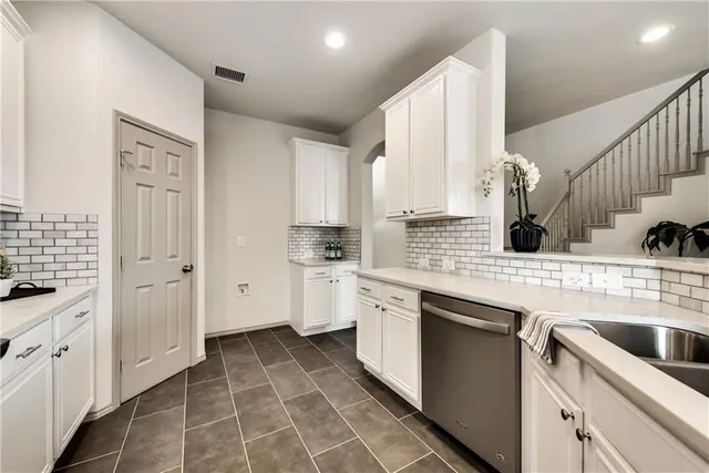a kitchen with white cabinets and appliances