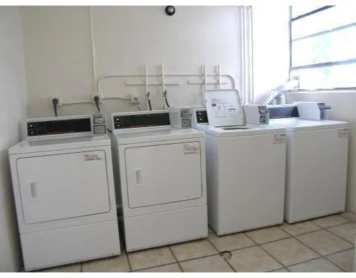 a view of washer and dryer with bathroom in the background