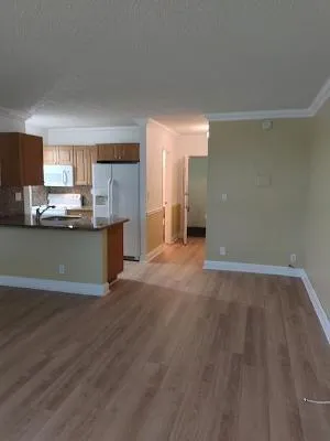 a view of a kitchen with a sink wooden cabinets and a window