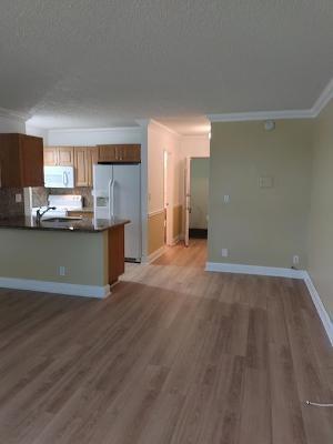 2501 Riverside Drive, Unit 218 Coral Springs, FL 33065 - Photo 3 of 15 a view of a kitchen with a sink wooden cabinets and a window