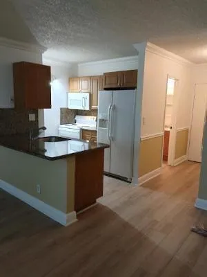 a kitchen with stainless steel appliances granite countertop a refrigerator and a sink