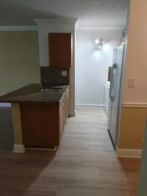 a kitchen with granite countertop a refrigerator and a stove