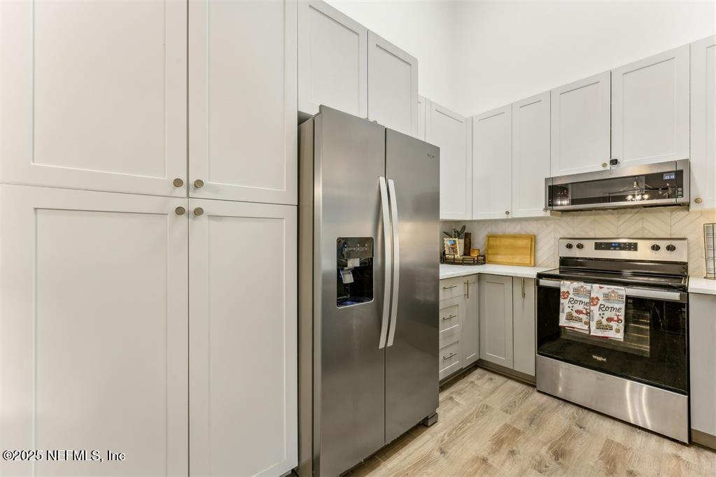1601 Nectarine Street, Unit I5 Fernandina Beach, FL 32034 - Photo 6 of 22 a metallic refrigerator freezer and a stove sitting inside of a kitchen