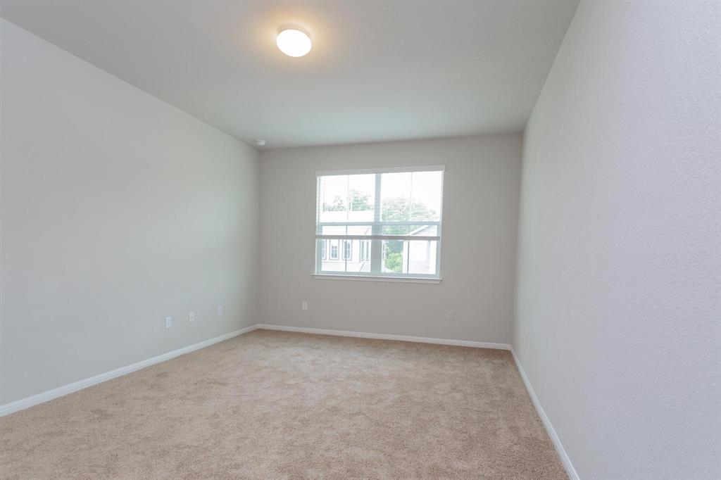 14614 Frankel Loop Pflugerville, TX 78660 - Photo 8 of 15 A well-lit bedroom offering plush carpeting and a serene neighborhood view.