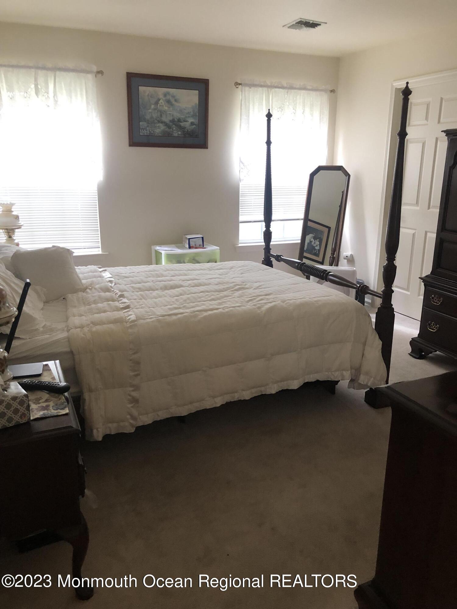 32 Meadows Lane Whiting, NJ 08759 - Photo 5 of 12 a bedroom with a bed a mirror on dresser and a window