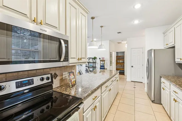 a kitchen with stainless steel appliances granite countertop a stove and a microwave