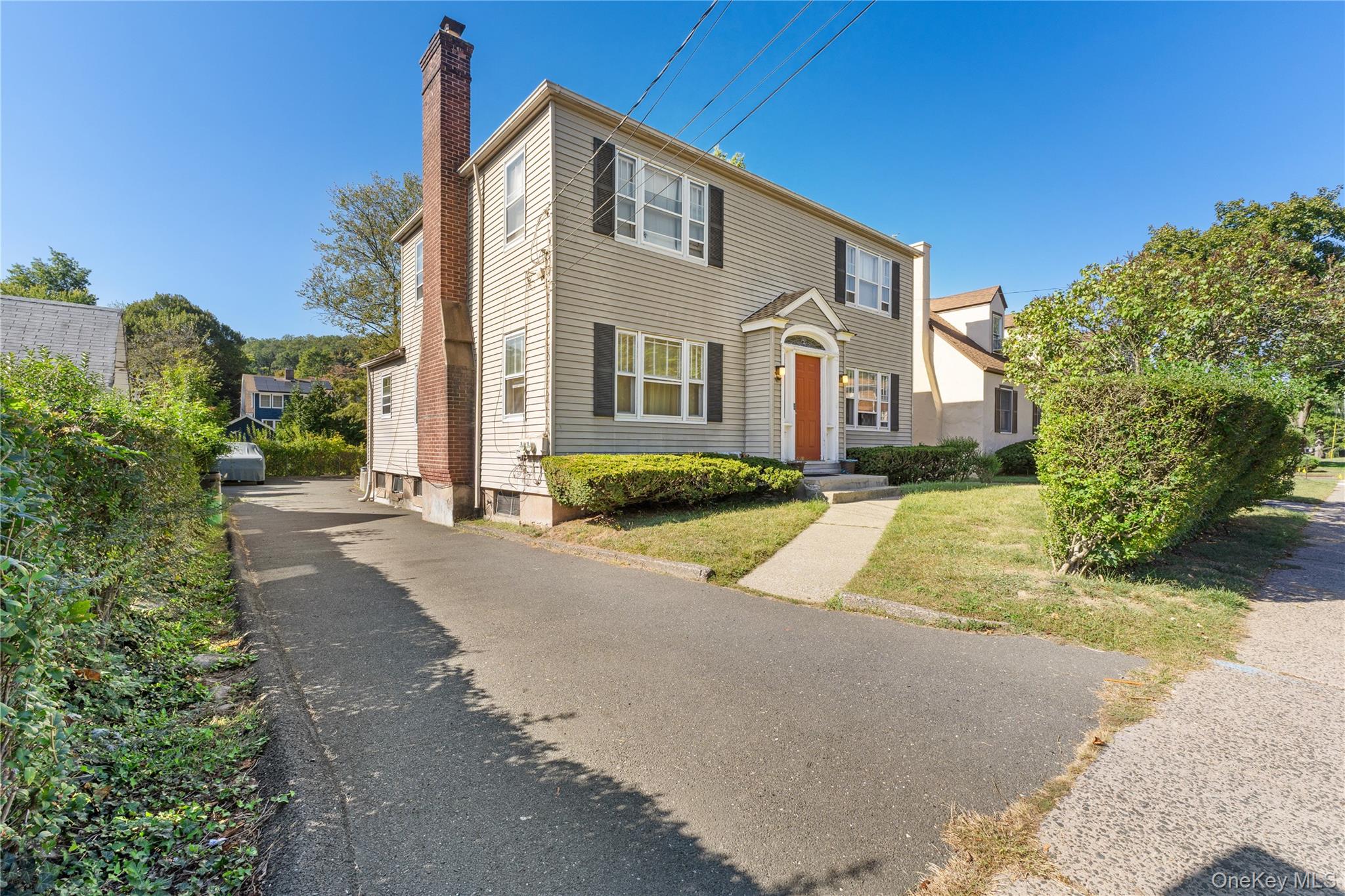 a front view of a house with a yard and trees