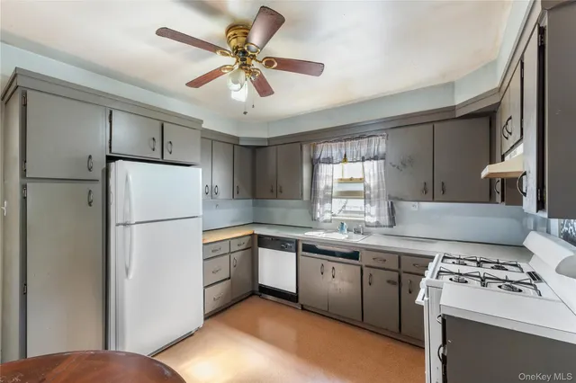 a kitchen with stainless steel appliances granite countertop a refrigerator a sink a stove and white cabinets