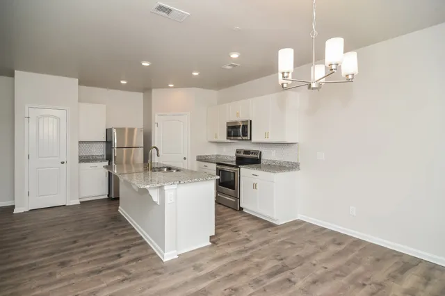 a open kitchen with white cabinets and stainless steel appliances