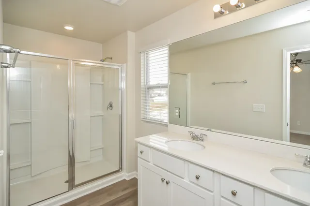 a bathroom with a shower sink and mirror