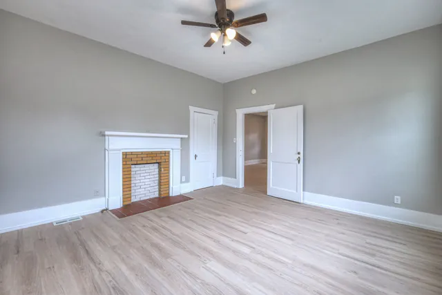 a view of an empty room with a window and a ceiling fan