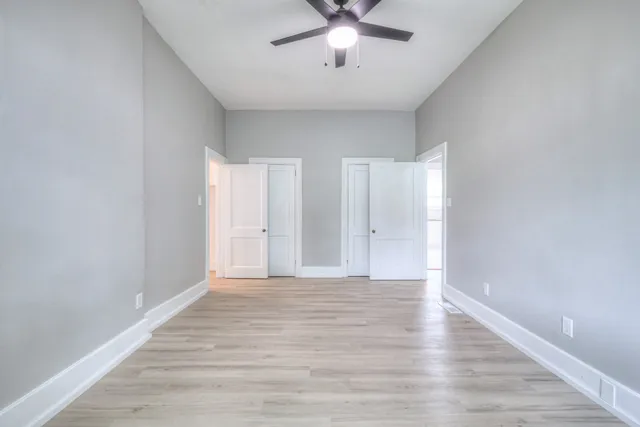 a view of an empty room with wooden floor