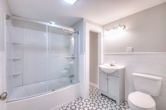 a bathroom with a sink a toilet and shower