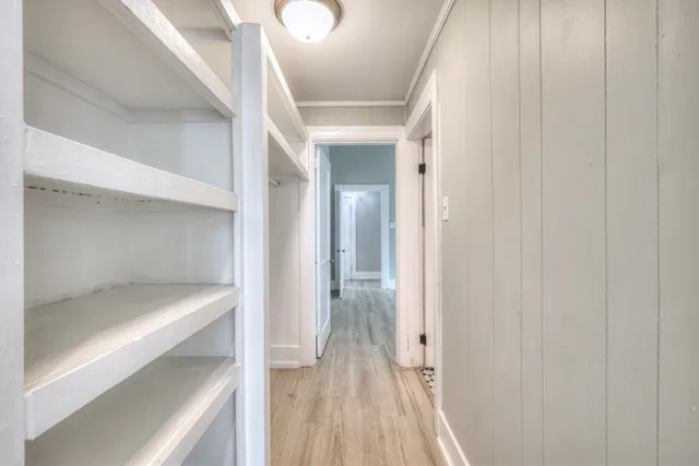 a view of a hallway with wooden floor and staircase