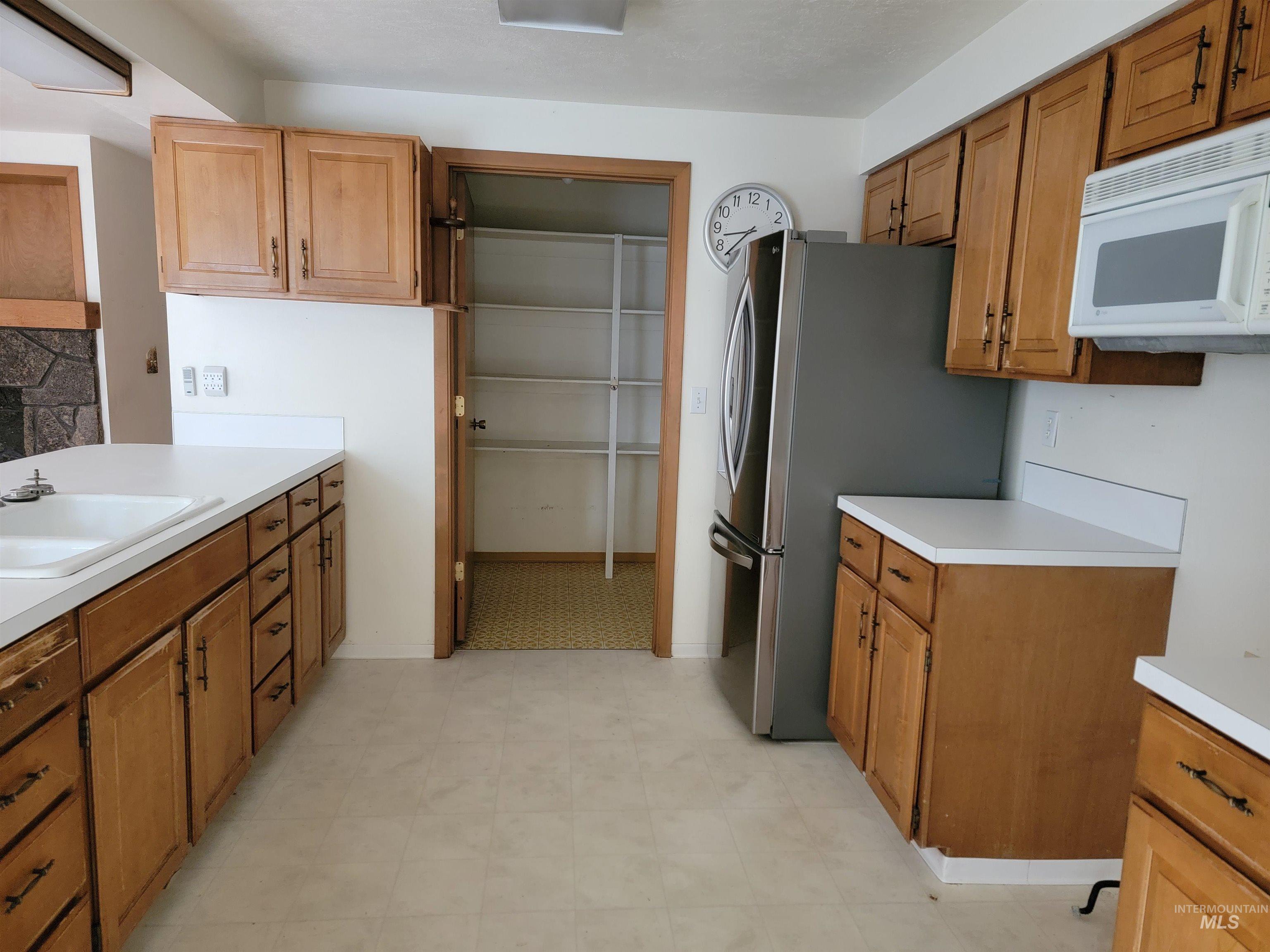 3311 Snowflake Way Boise, ID 83706 - Photo 6 of 14 Kitchen with light countertops, white microwave, freestanding refrigerator, and light floors