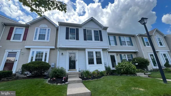 a front view of a house with a yard and trees