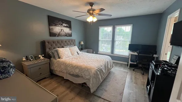 a bedroom with a bed television and a window