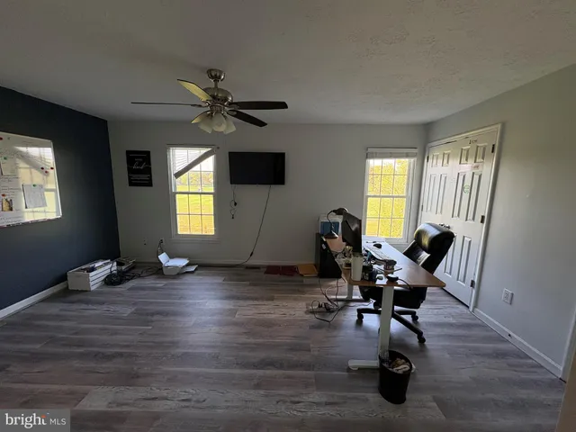 a view of a livingroom with workspace and a window