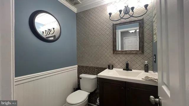 a bathroom with a toilet sink vanity and mirror