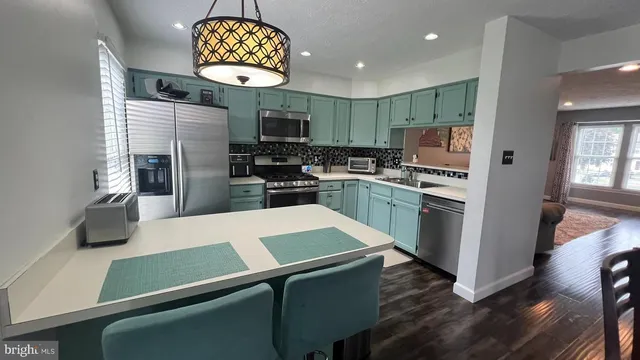 a kitchen with kitchen island a refrigerator a stove a sink and a oven