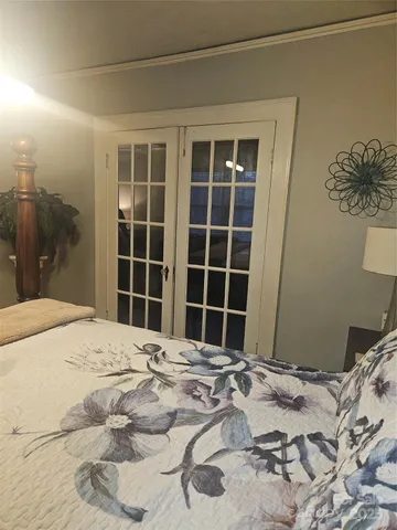 a spacious bedroom with a bed and a chandelier