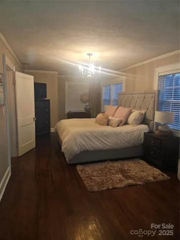 a large bed sitting in a spacious bedroom and kitchen