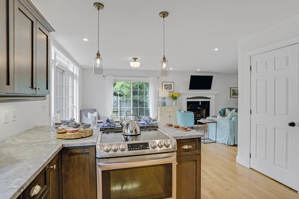 128-136 Spring Street Tisbury, MA 02568 - Photo 11 of 42 a kitchen with stainless steel appliances kitchen island granite countertop a sink a stove and a wooden floors