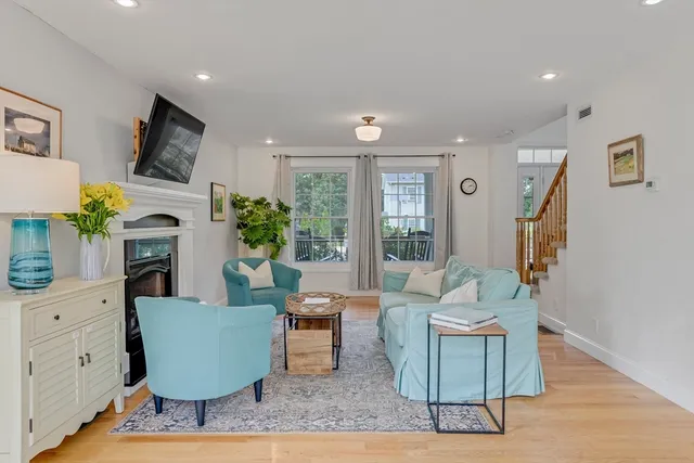 a living room with furniture a large window and a fireplace