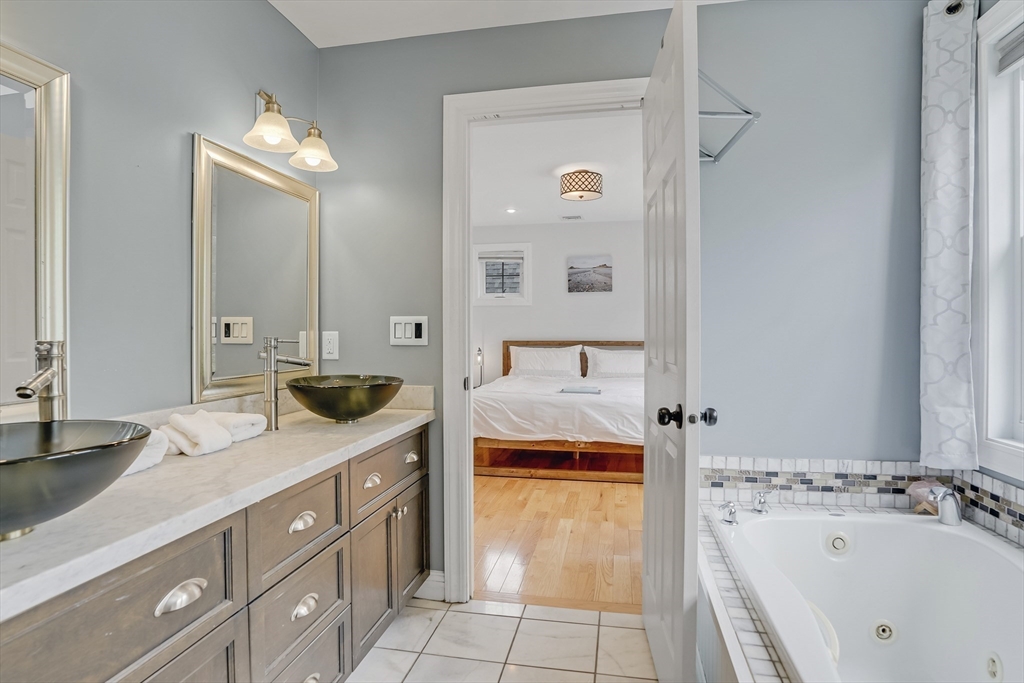 128-136 Spring Street Tisbury, MA 02568 - Photo 23 of 42 a spacious bathroom with a tub sink and mirror