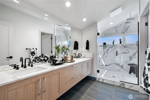 a bathroom with double vanity and a mirror
