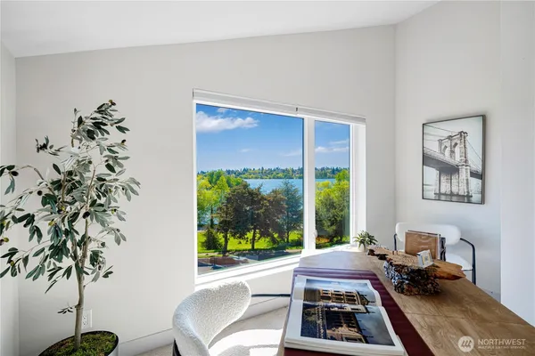 a bed sitting in a bedroom next to a window with potted plants on table