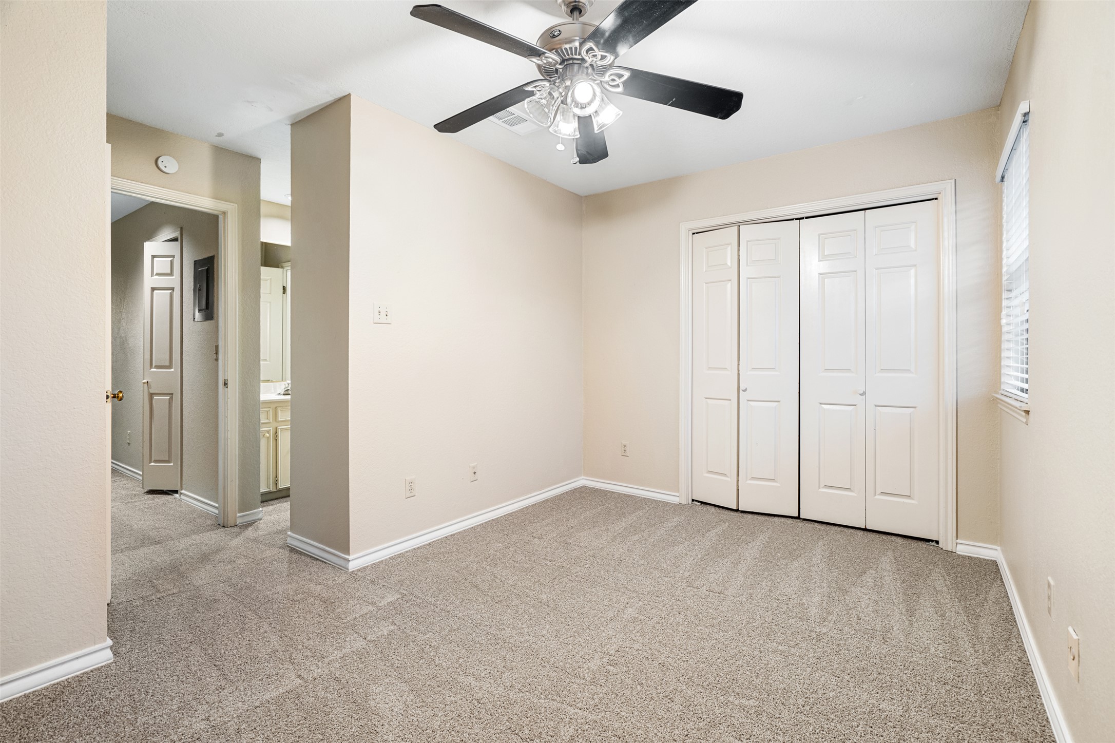 2408 Enfield Road, Unit 211 Austin, TX 78703 - Photo 23 of 26 Unfurnished bedroom with light colored carpet, a closet, and ceiling fan
