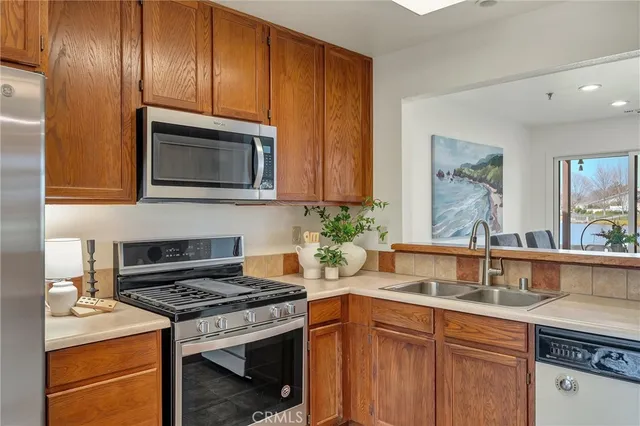 a kitchen with granite countertop cabinets stainless steel appliances and a sink