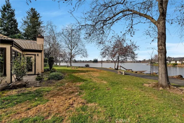 a view of a lake with couches and wooden fence