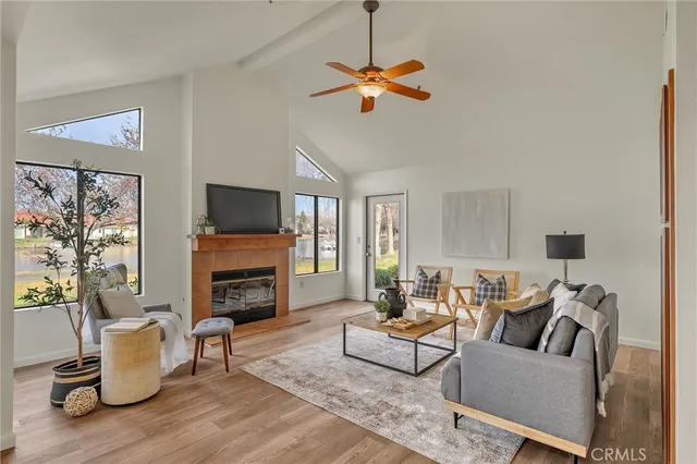a living room with furniture a fireplace a flat screen tv and a large window