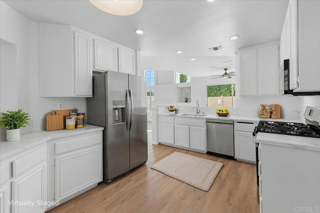 1275 Natoma Way, Unit B Oceanside, CA 92057 - Photo 1 of 1 a kitchen with stainless steel appliances a refrigerator sink and white cabinets