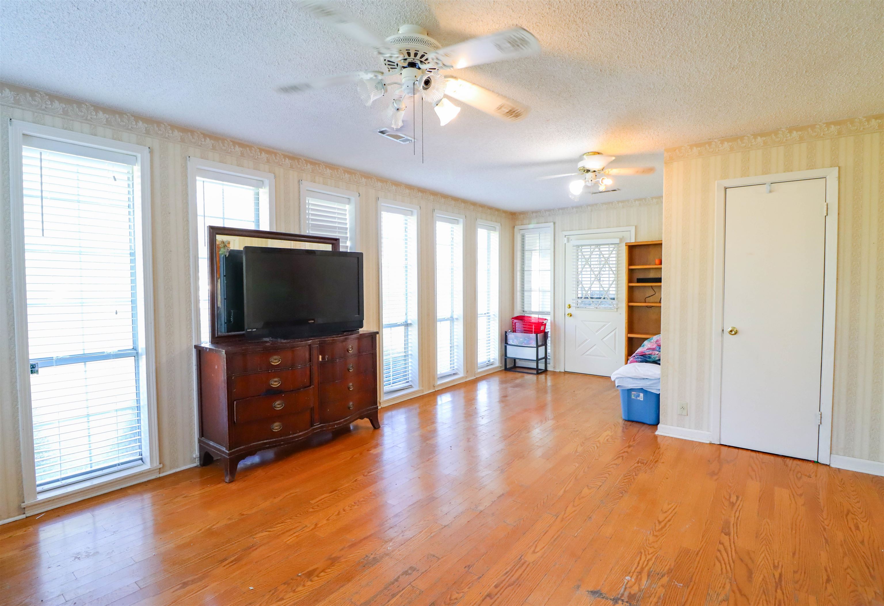 5551 Asbury Glimp Road Ripley, TN 38063 - Photo 12 of 28 wooden floor in an empty room with a window and a kitchen