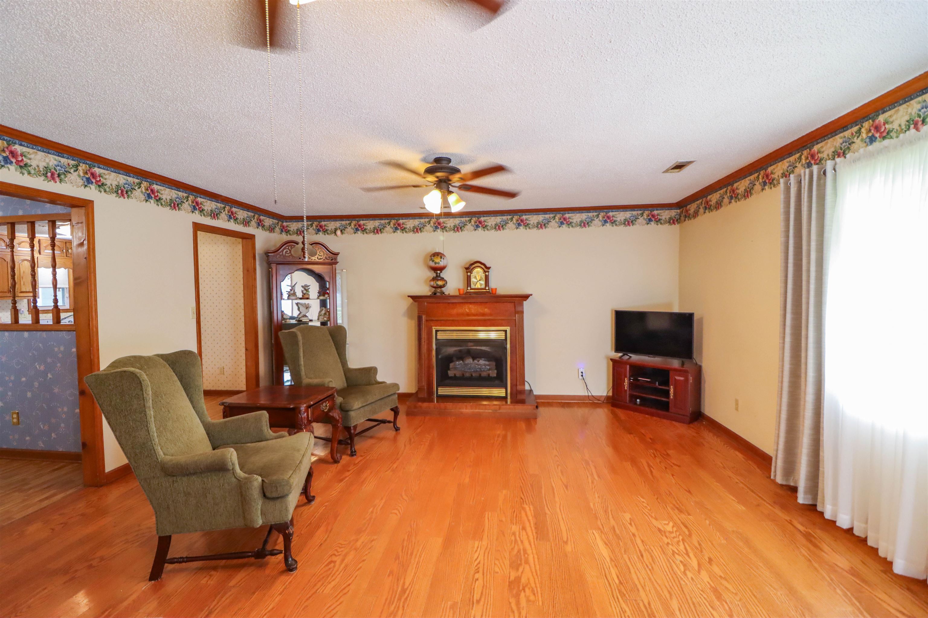 5551 Asbury Glimp Road Ripley, TN 38063 - Photo 13 of 28 a living room with furniture a fireplace and a flat screen tv