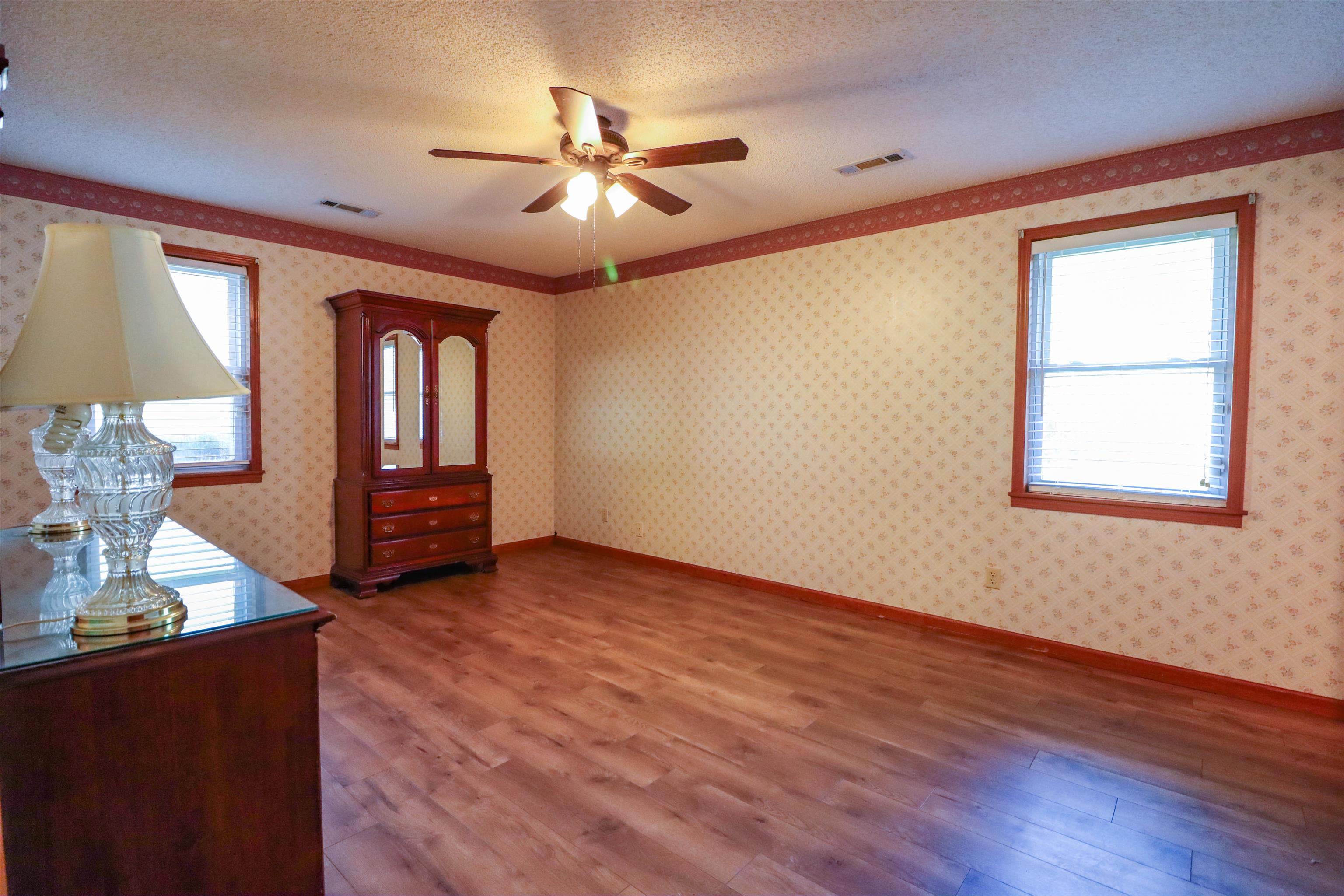 5551 Asbury Glimp Road Ripley, TN 38063 - Photo 20 of 28 a view of an empty room with wooden floor and a window