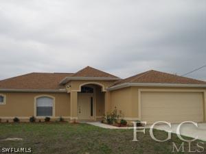 2817 13th Street Southwest Lehigh Acres, FL 33976 - Photo 1 of 9 a front view of a house with garden