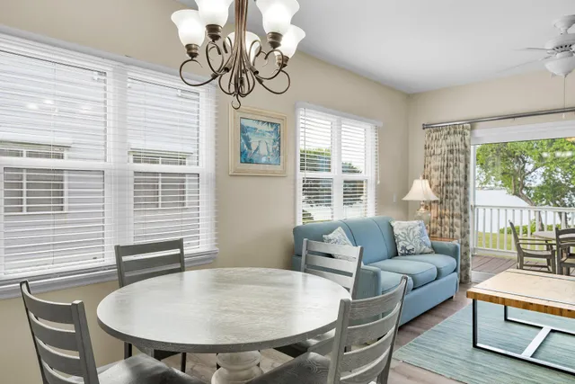 a kitchen with stainless steel appliances granite countertop a dining table chairs refrigerator and microwave