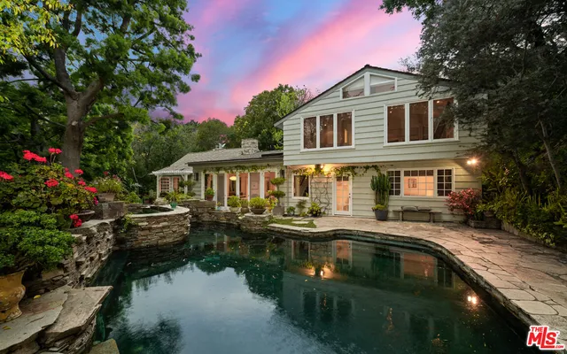 a front view of a house with swimming pool and sitting area