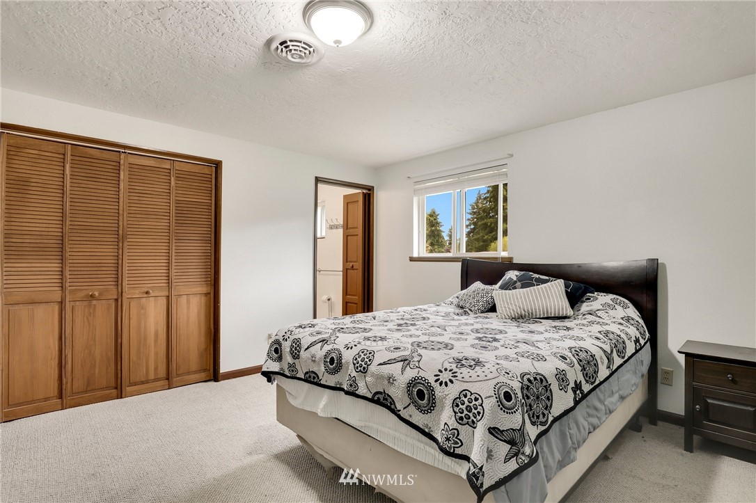 19206 Loganberry Street Southwest Rochester, WA 98579 - Photo 21 of 39 a bedroom with a bed lamp and a window
