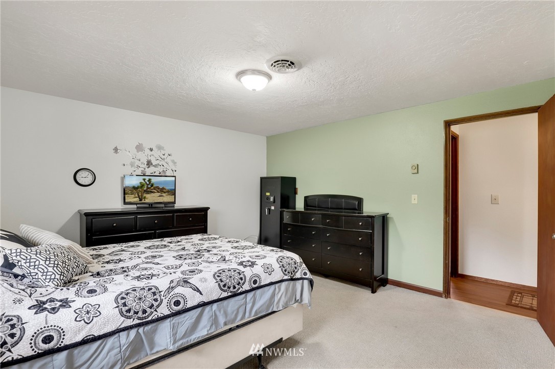 19206 Loganberry Street Southwest Rochester, WA 98579 - Photo 22 of 39 a bedroom with a bed and dresser