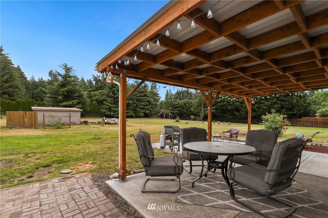 19206 Loganberry Street Southwest Rochester, WA 98579 - Photo 29 of 39 a view of a patio with table and chairs potted plants with large tree