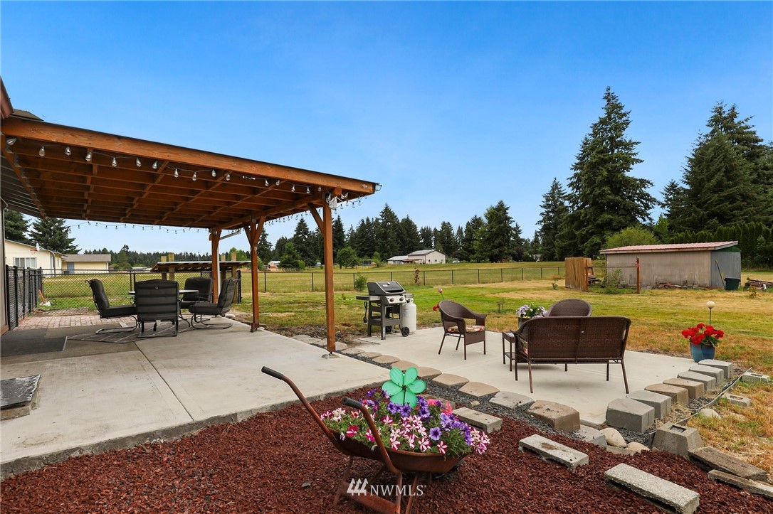 19206 Loganberry Street Southwest Rochester, WA 98579 - Photo 30 of 39 a view of a patio with a table and chairs under an umbrella