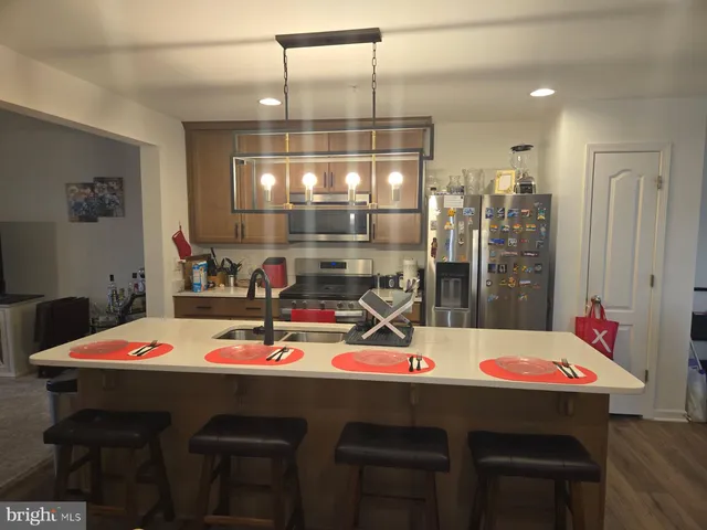 a dining room with a table chairs and kitchen view